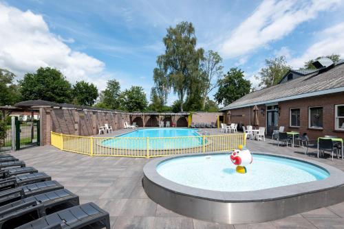 a large swimming pool with chairs around it at Forestlodge in het Vechtdal - 5 persoons in Hardenberg
