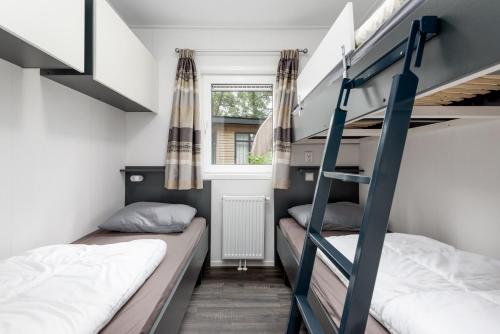 a room with two bunk beds and a window at Forestlodge in het Vechtdal - 5 persoons in Hardenberg