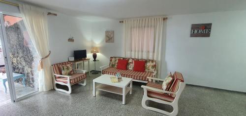 APARTAMENTO LOS CACTUS في Echedo: غرفة معيشة مع أريكة وكراسي وطاولة