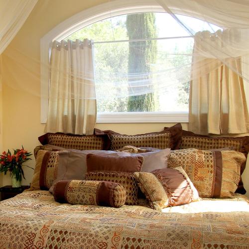 a bed with pillows on it in front of a window at Bella Vista Bed and Breakfast in Coloma