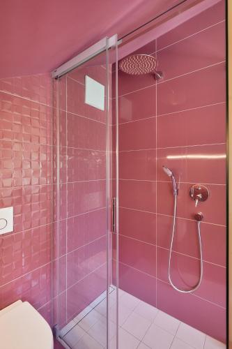 a bathroom with a shower with pink tiles at Kircherhof in Bressanone