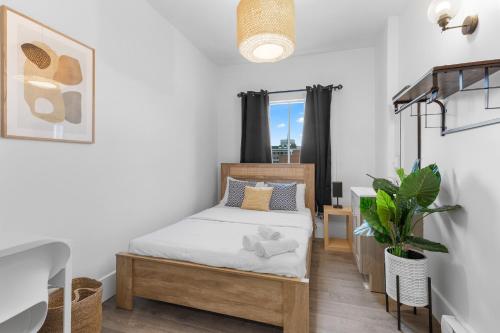 a small bedroom with a bed and a desk at Le Sand & Stone Hotel in Montréal