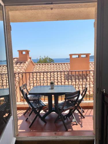 une table et des chaises sur un balcon avec vue sur l'océan dans l'établissement CAP SUD 83 APPART VUE MER 200m plages, à Hyères
