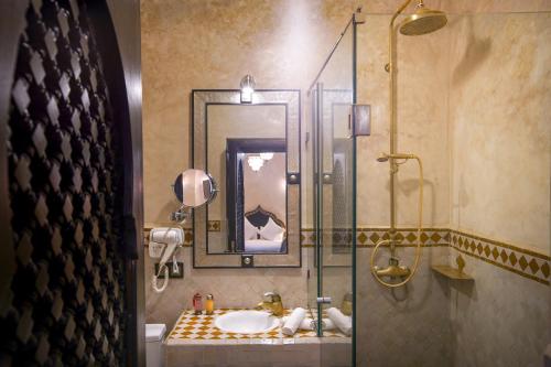y baño con ducha acristalada y lavamanos. en Riad Mazaj en Marrakech