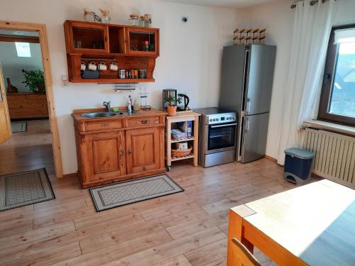 una cocina con nevera de acero inoxidable y armarios de madera en Neugärten, en Busenberg