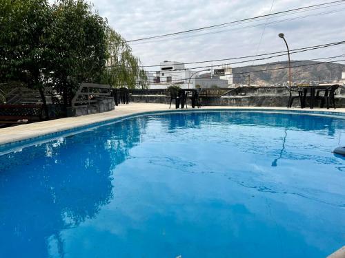 une grande piscine bleue avec des personnes debout autour de celle-ci dans l'établissement Montecatini Hotel, à Villa Carlos Paz