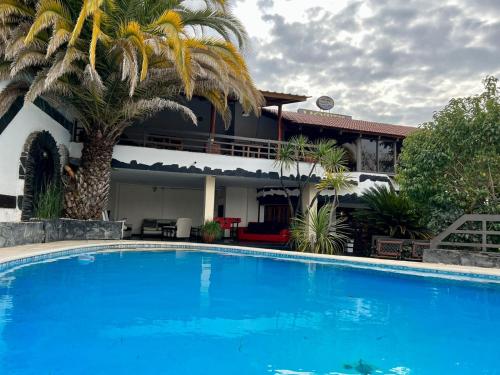 une grande piscine bleue en face d'une maison dans l'établissement Montecatini Hotel- By HVH, à Villa Carlos Paz