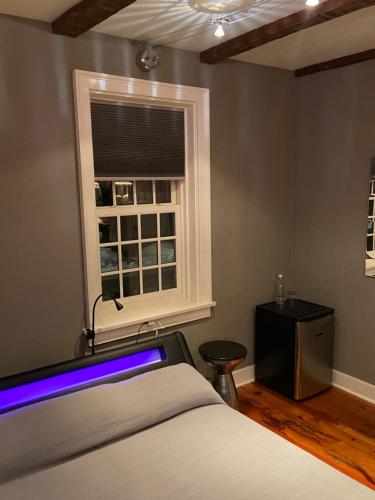 a bedroom with a bed and a window with a blue light at Old Ivy Walk in Niagara on the Lake
