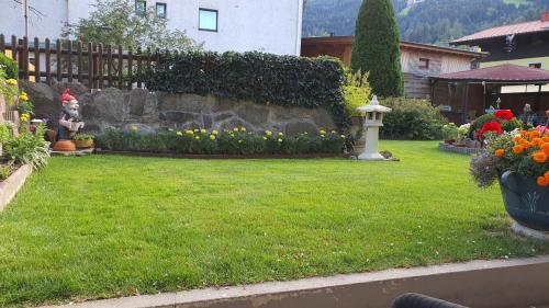 einen Garten mit Blumen und einer Steinmauer in der Unterkunft Apartmenthaus Erna in Bad Hofgastein