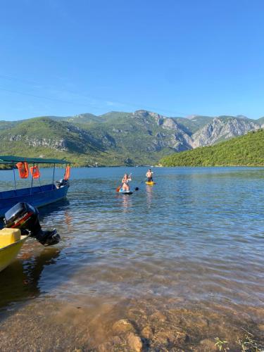 a group of people in the water near a boat at Agora Farmhouse in Koman