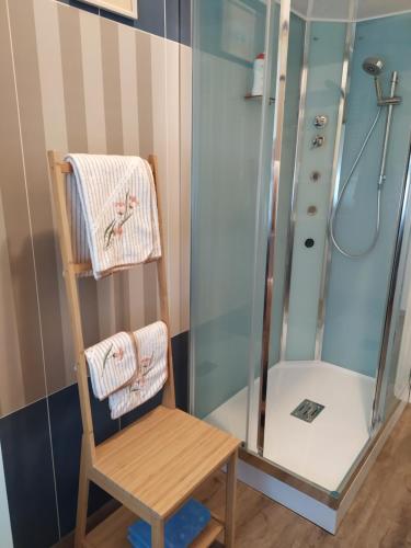 a bathroom with a shower and a wooden chair at Casa Vacanze I Giardini di Marzo in San Giorgio Di Mantova