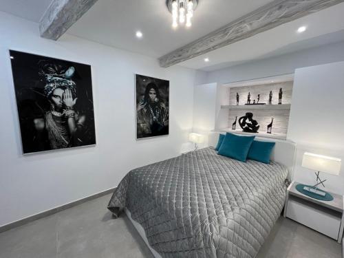 1 dormitorio con 1 cama y algunas fotos en la pared en Luxury house Atlantico private heated pool, en Adeje
