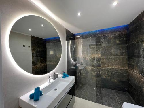 a bathroom with a sink and a mirror at Luxury house Atlantico private heated pool in Adeje