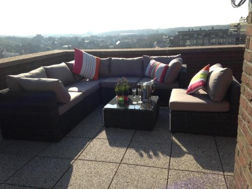 two couches and a table on a balcony at Duplex Penthouse Plaza in De Panne