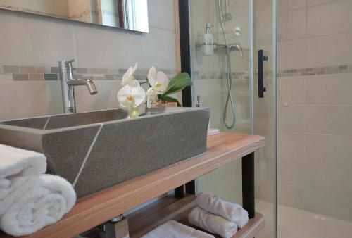 uma casa de banho com um lavatório e um chuveiro com toalhas em Le Acacie em Torreano