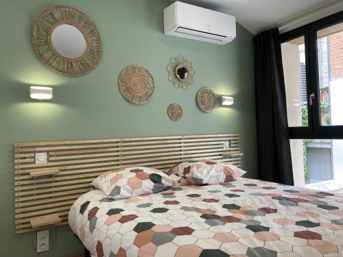 Schlafzimmer mit einem Bett und Spiegeln an der Wand in der Unterkunft L ATELIER cour clim 3 ETOILES in Moissac