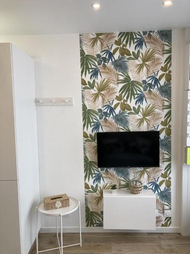 a living room with a tv and a wall with a wallpaper at L'ATELIER - à coté abbatiale - clim reversible - Ideal couples in Moissac