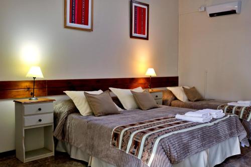 a hotel room with two beds and two lamps at Portal de La Cumbre in La Cumbre