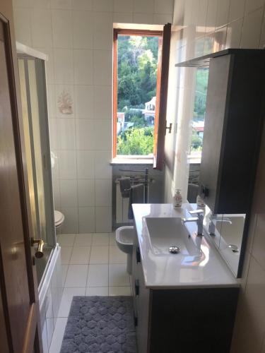 bagno con lavandino, servizi igienici e finestra di Mario’s House a Ischia