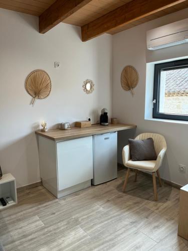 a kitchen with a counter and a chair in a room at Le Mas d'Archas Montélimar Sud in Allan