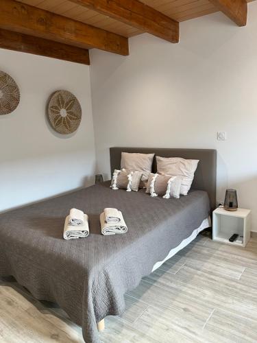 a bedroom with a large bed with towels on it at Le Mas d'Archas Montélimar Sud in Allan