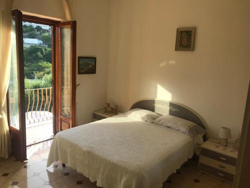 una camera con letto e porta di accesso a un balcone di Mario’s House a Ischia