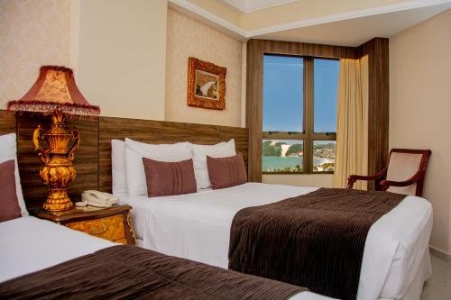 a hotel room with two beds and a window at Best Western Premier Majestic Ponta Negra Beach in Natal