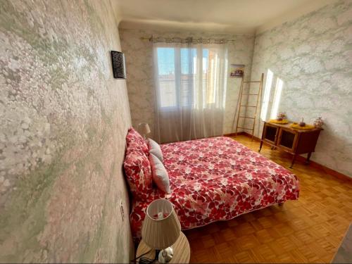 - une chambre avec un lit rouge et un mur dans l'établissement Très grand appartement à 10 min à pied du centre, à Castres