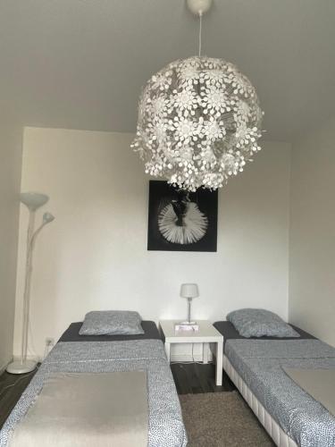 een slaapkamer met 2 bedden en een kroonluchter bij Studio 5 Near Basel Airport in Saint-Louis