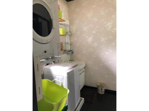 a small bathroom with a washing machine and a microwave at Fukugi no Yado - Vacation STAY 94994v in Amami