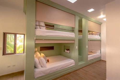 a room with four bunk beds with a window at Azcapri Villa Boutique & Spa in Cancún
