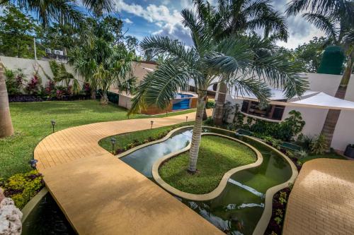 a house with a swimming pool and a palm tree at Azcapri Villa Boutique & Spa in Cancún