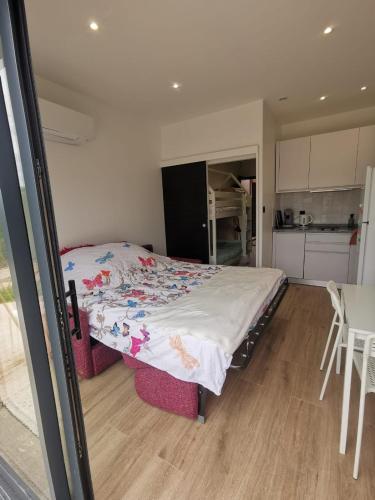 une chambre avec un lit et une cuisine dans l'établissement L'escapade, à 5 minutes de l'A6, à Dracé