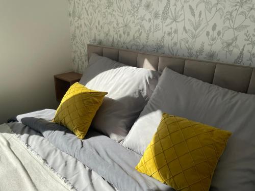 a bed with two yellow pillows on it at Calm Apartment nr 8 in Olsztyn