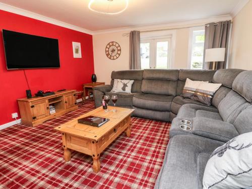 a living room with a couch and a tv at Argyle House in Rothesay