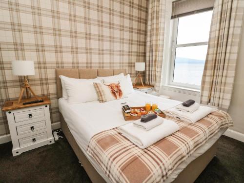a bedroom with a bed with towels and a window at Argyle House in Rothesay