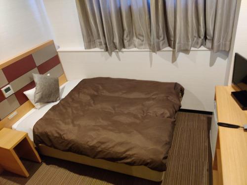 um pequeno quarto com uma cama e uma janela em HOTEL SUNROAD - Vacation STAY 04184v em Amakusa