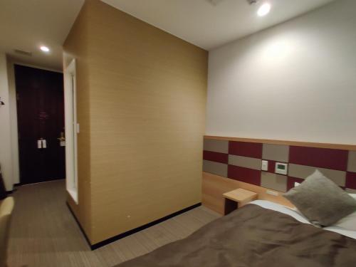 um quarto de hotel com uma cama e uma porta em HOTEL SUNROAD - Vacation STAY 04184v em Amakusa