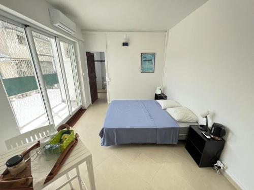 1 dormitorio con 1 cama y 2 ventanas en RETE ZEN GUESTHOUSE en Pointe-à-Pitre