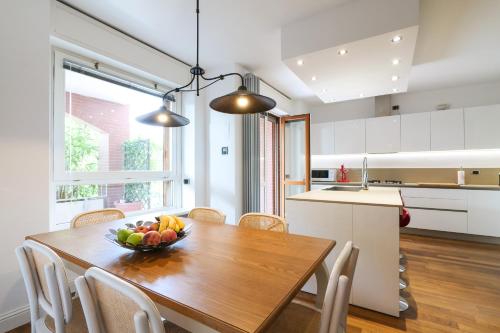 a kitchen with a wooden table with a bowl of fruit at SAN SIRO STADIUM LUXURY PLUS in Milan
