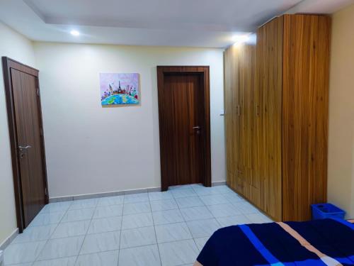 a bedroom with a bed and wooden closets at Abuja Apartments 24 in Abuja