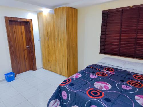 a bedroom with a bed and a large window at Abuja Apartments 24 in Abuja