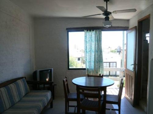 Una sala de estar con un sofá y una mesa y una ventana. en La Casa del Caminante, en Aguas Dulces