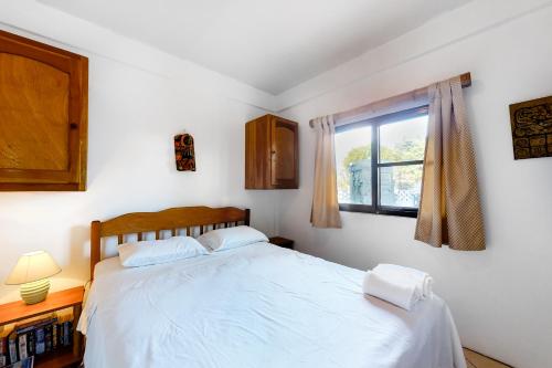 1 dormitorio con cama blanca y ventana en Mayan Falls Gold Standard and Corridor Certified, en Caye Caulker