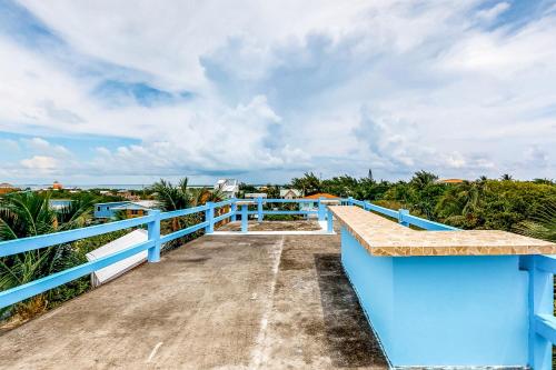 a boardwalk leading to the beach from a blue building at Mayan Falls Gold Standard and Corridor Certified in Caye Caulker