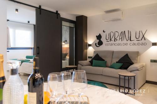 uma sala de estar com um sofá e uma mesa com copos de vinho em Urbanlux Olimpia Pet Friendly em Albacete