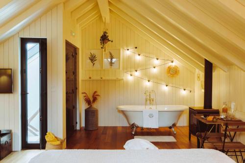 a bedroom with a tub and a table and a bed at Oliveiras Village — Agroturismo in Amarante