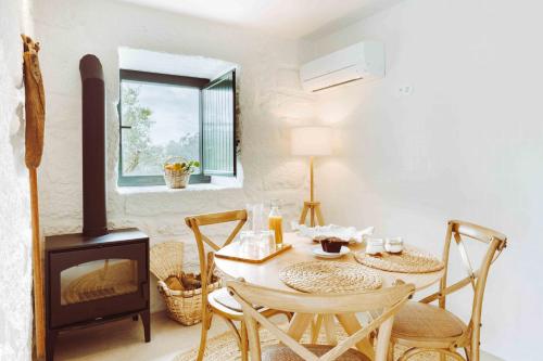 a dining room with a table and a wood stove at Oliveiras Village — Agroturismo in Amarante