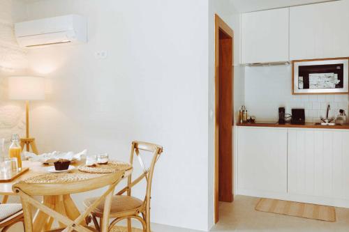 a kitchen and dining room with a table and chairs at Oliveiras Village — Agroturismo in Amarante