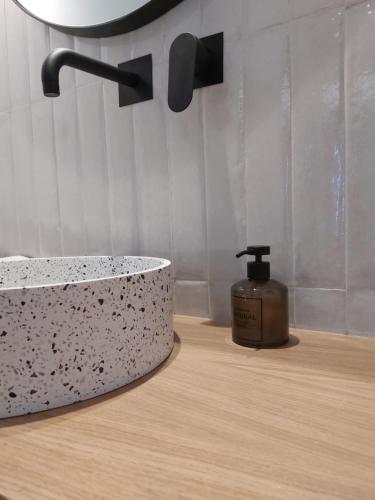 a bathroom with a sink and a bottle of soap at Anastasia Apartments in Bali